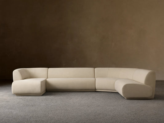 Cream Gianni Armless Four-Piece Chaise Sectional with rounded left corner, two center sections, and right chaise, on wood floor.