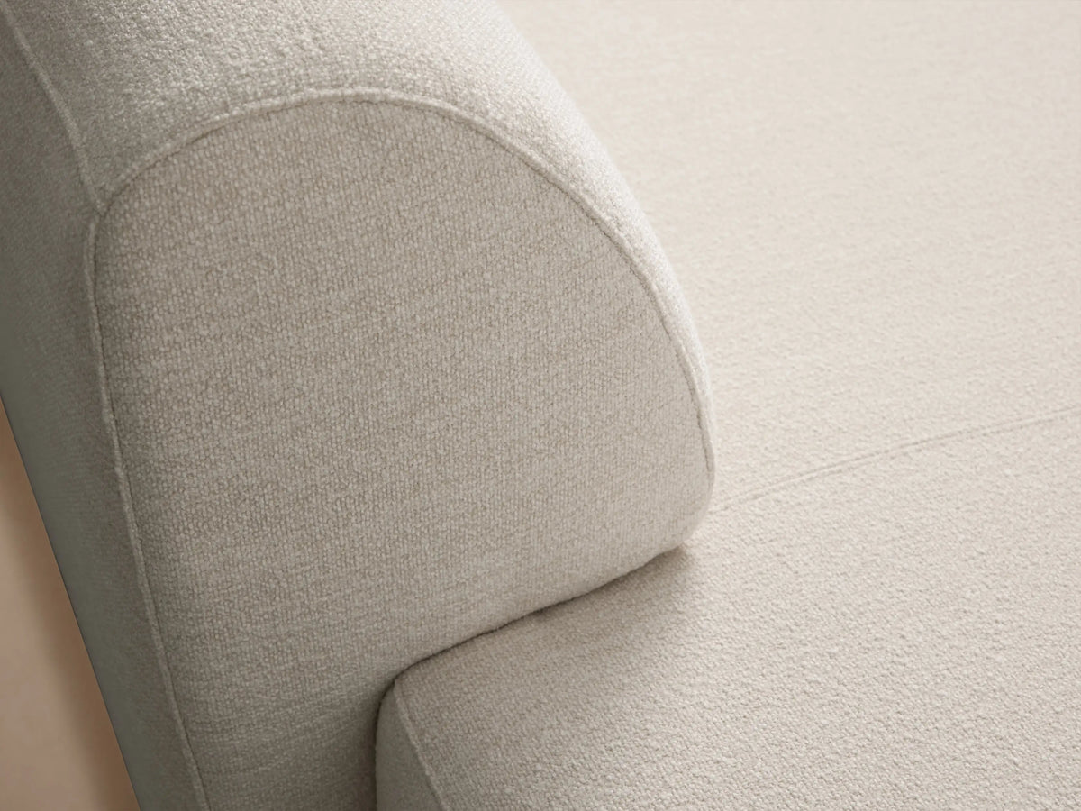 Light beige textured Gianni Chaise, modern style with rounded edges, angled view on a wooden floor.