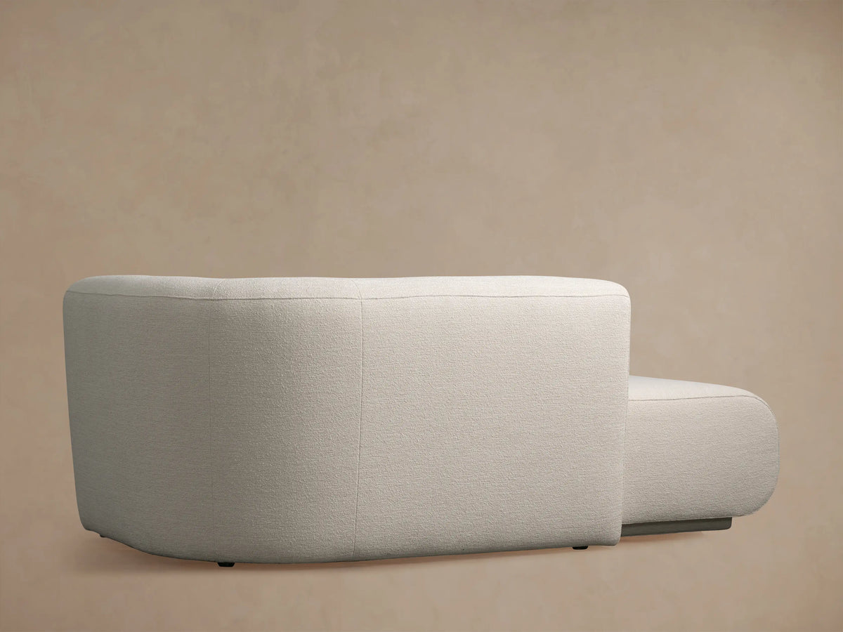 Textured off-white Gianni Chaise with a curved armrest and seat visible in a close-up shot.