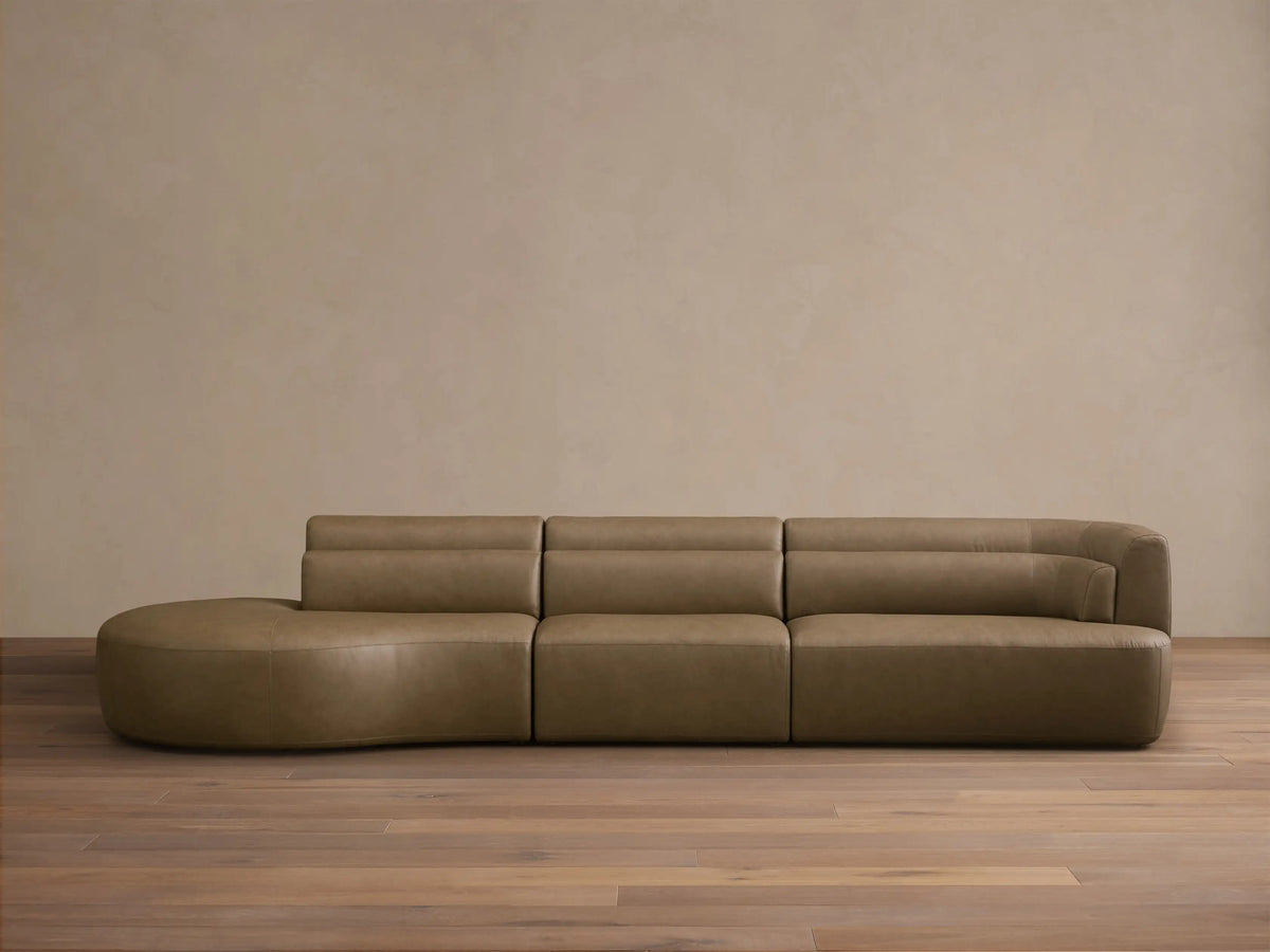 Front view of the taupe Lovina Leather Three-Piece Bumper Sectional, featuring a left bumper chaise, armless chair, and right arm chair.