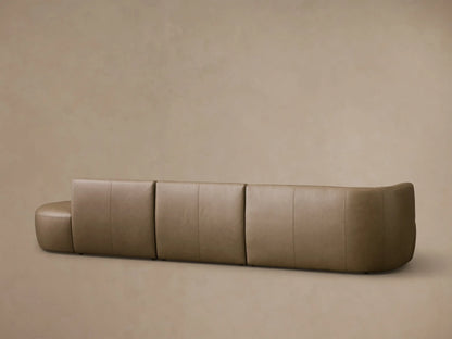 Close-up of the taupe Lovina Leather Three-Piece Bumper Sectional, highlighting the curved corner and stitched seam details.