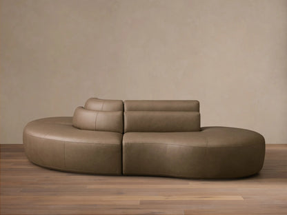 Front view of the taupe Lovina Leather Three-Piece Sectional with Ottoman, showing its curved modular design.