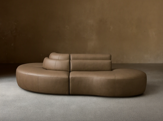 Front view of the taupe Lovina Leather Three-Piece Sectional with Ottoman, showing its curved modular design.