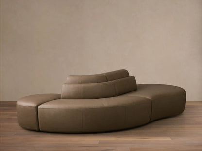 Front view of the taupe Lovina Leather Three-Piece Sectional with Ottoman, showing its curved modular design.