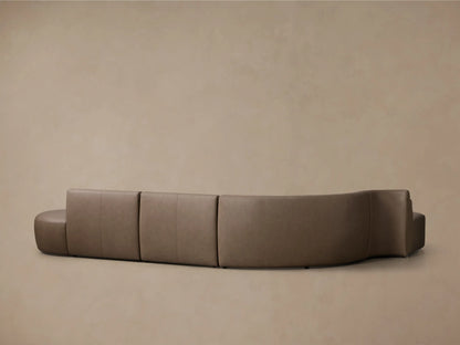 Front view of the taupe Lovina Leather Four-Piece Bumper Sectional, showcasing its elegant curved design and distinct sections.