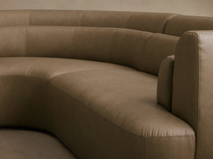 Close-up of the taupe leather Lovina Leather Four-Piece Sectional with Ottoman, showing its curved design and armrest.