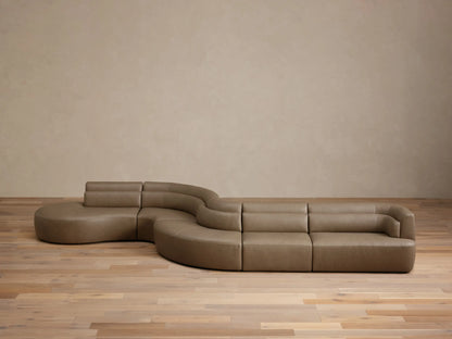 Full view of the taupe Lovina Leather Five-Piece Sectional, a modern, serpentine sofa with low backrests.