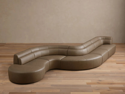 Front view of the taupe Lovina Leather Five-Piece Sectional, showcasing its unique serpentine curved design.