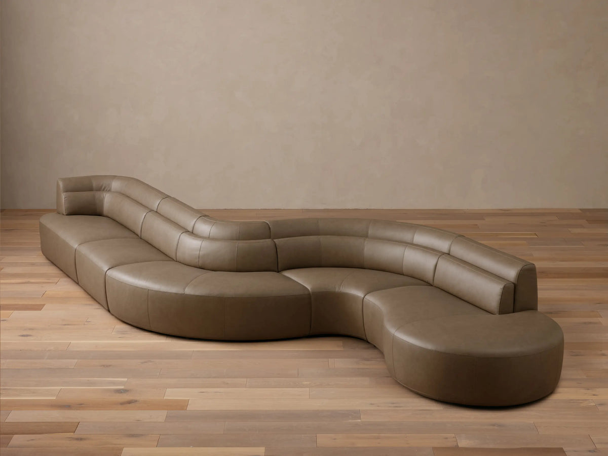 Front view of the light brown Lovina Leather Five-Piece Sectional, showcasing its curved, organic shape.