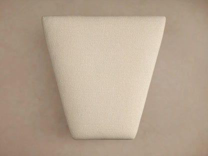 Lovina Ottoman in light beige textured fabric, rectangular with soft rounded corners, small dark feet, on a warm beige background.