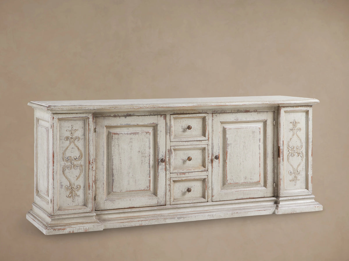 Vittoria Bell'Arte Console with hand-carved ivory grey and dark rust finish, ornate door detailing, brass knobs, and wood grain texture.