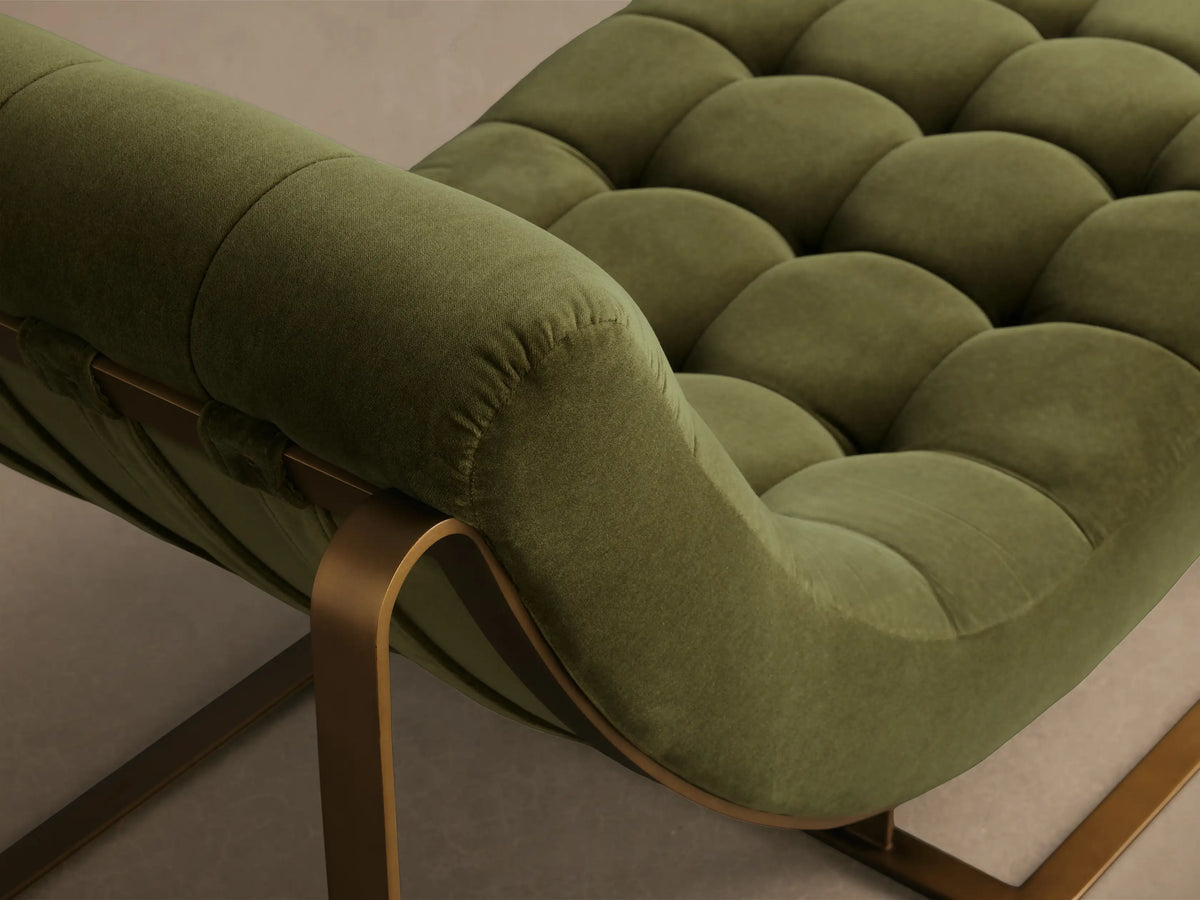 Side view of the green Callaway Chaise, featuring a tufted upholstered seat and back on a curved bronze metal frame.