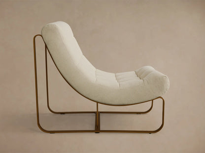 Side view of a cream textured Callaway Chair with a curved lounge design and a bronze metal sled base.