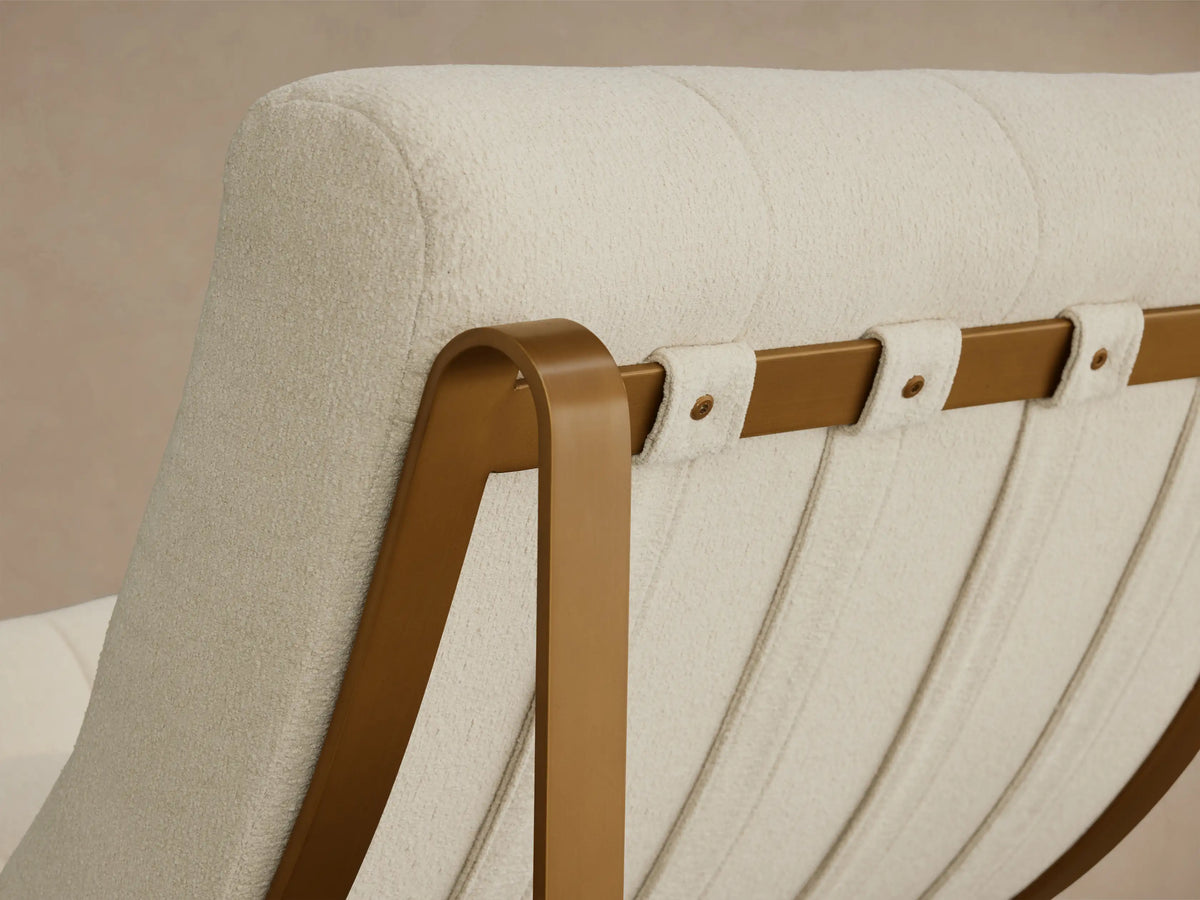 Angled back view of the cream textured Callaway Chair with a tufted seat and gold metal frame supporting vertical fabric straps.