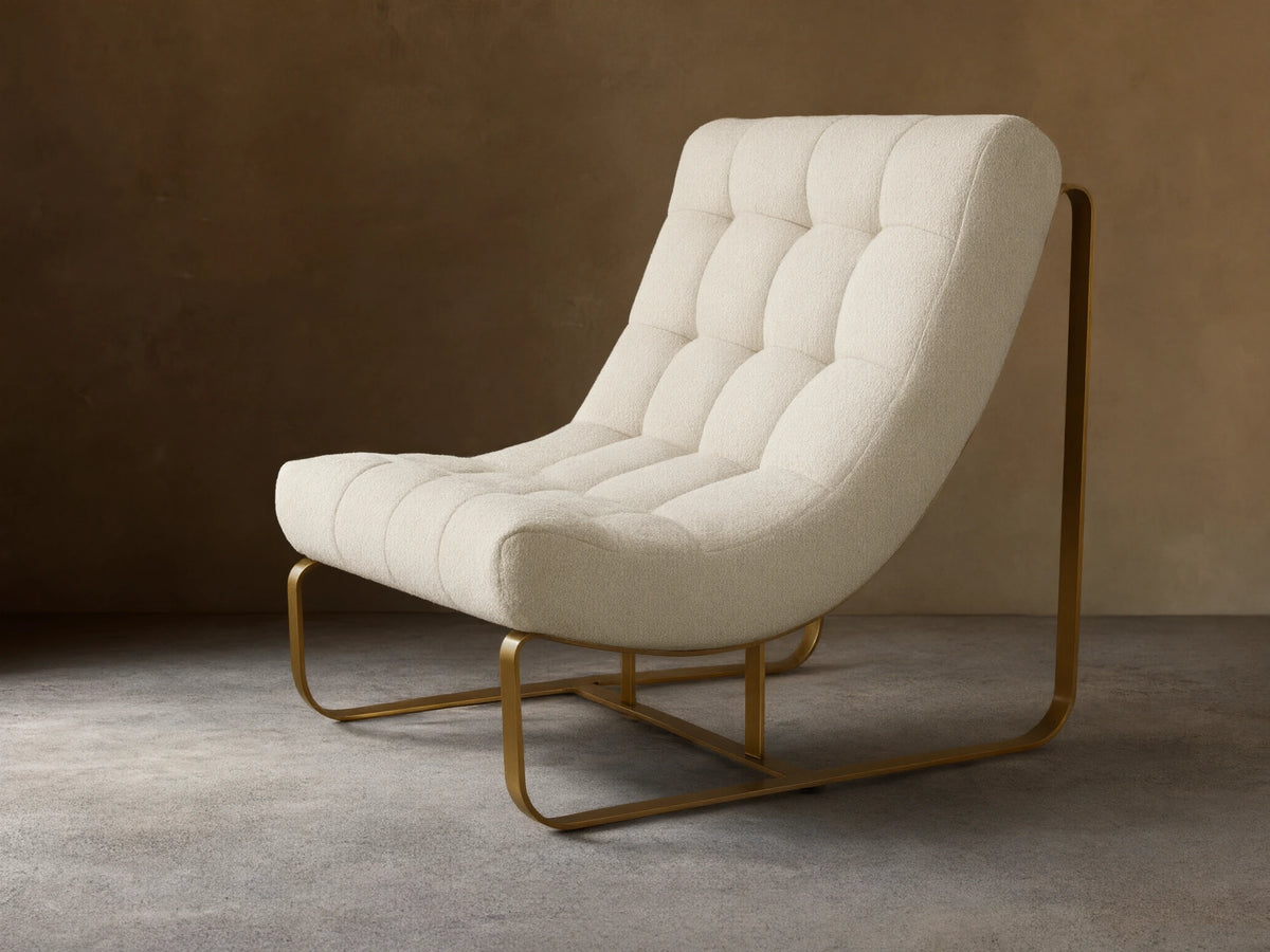 Front view of a cream boucle Callaway Chair with tufted cushions and a curved gold-toned metal frame.