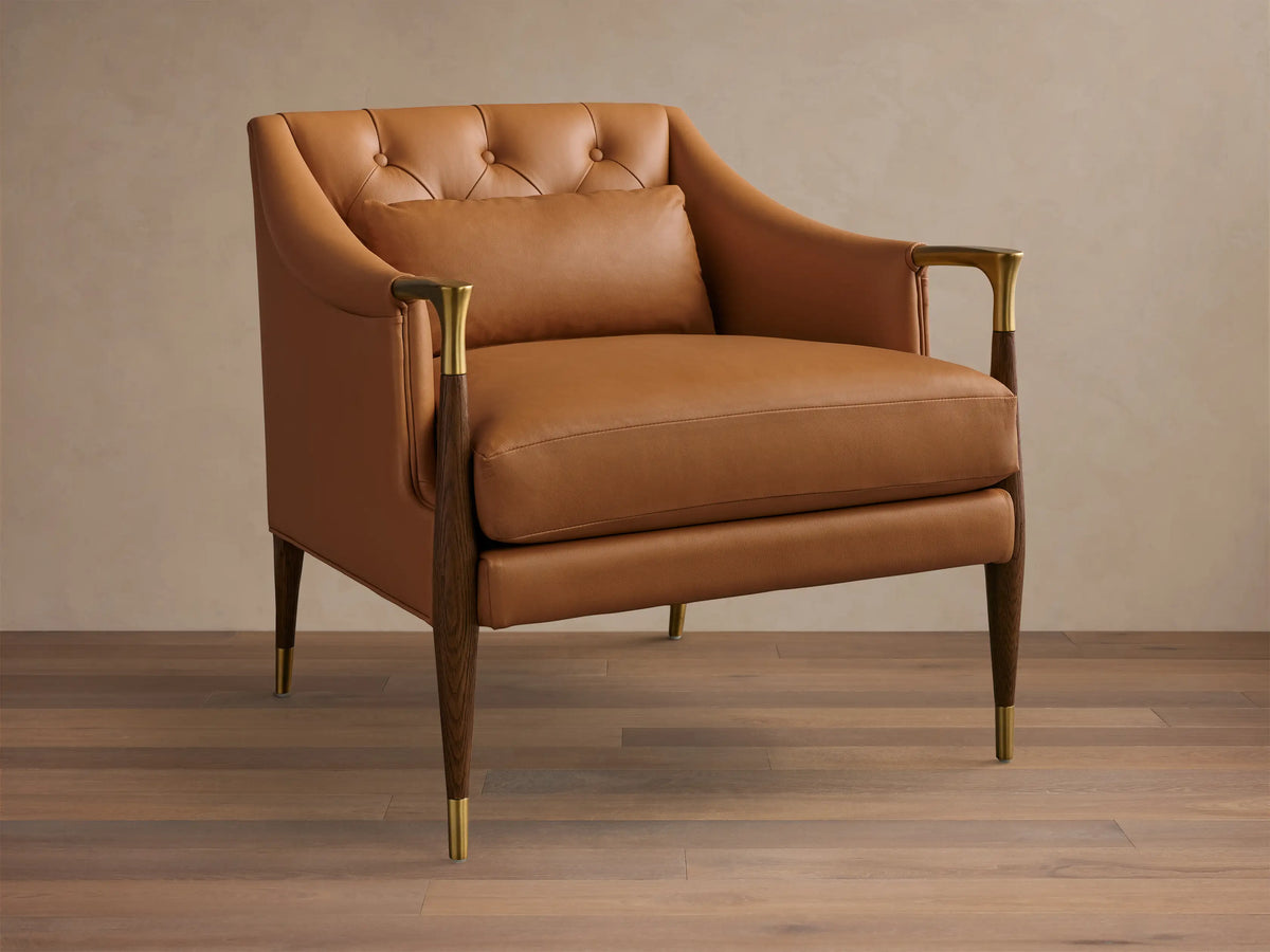 Front view of a Cognac Fisher Leather Club Chair with a button-tufted back, wood and brass armrests, tapered legs, and lumbar pillow.