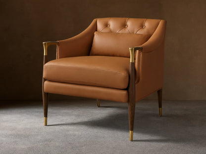Front view of a Cognac Fisher Leather Club Chair with a button-tufted back, wood and brass armrests, tapered legs, and lumbar pillow.