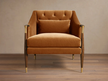 Front 3/4 view of a golden velvet Fisher Club Chair with a tufted back, matching lumbar pillow, dark wood legs, and brass accents.