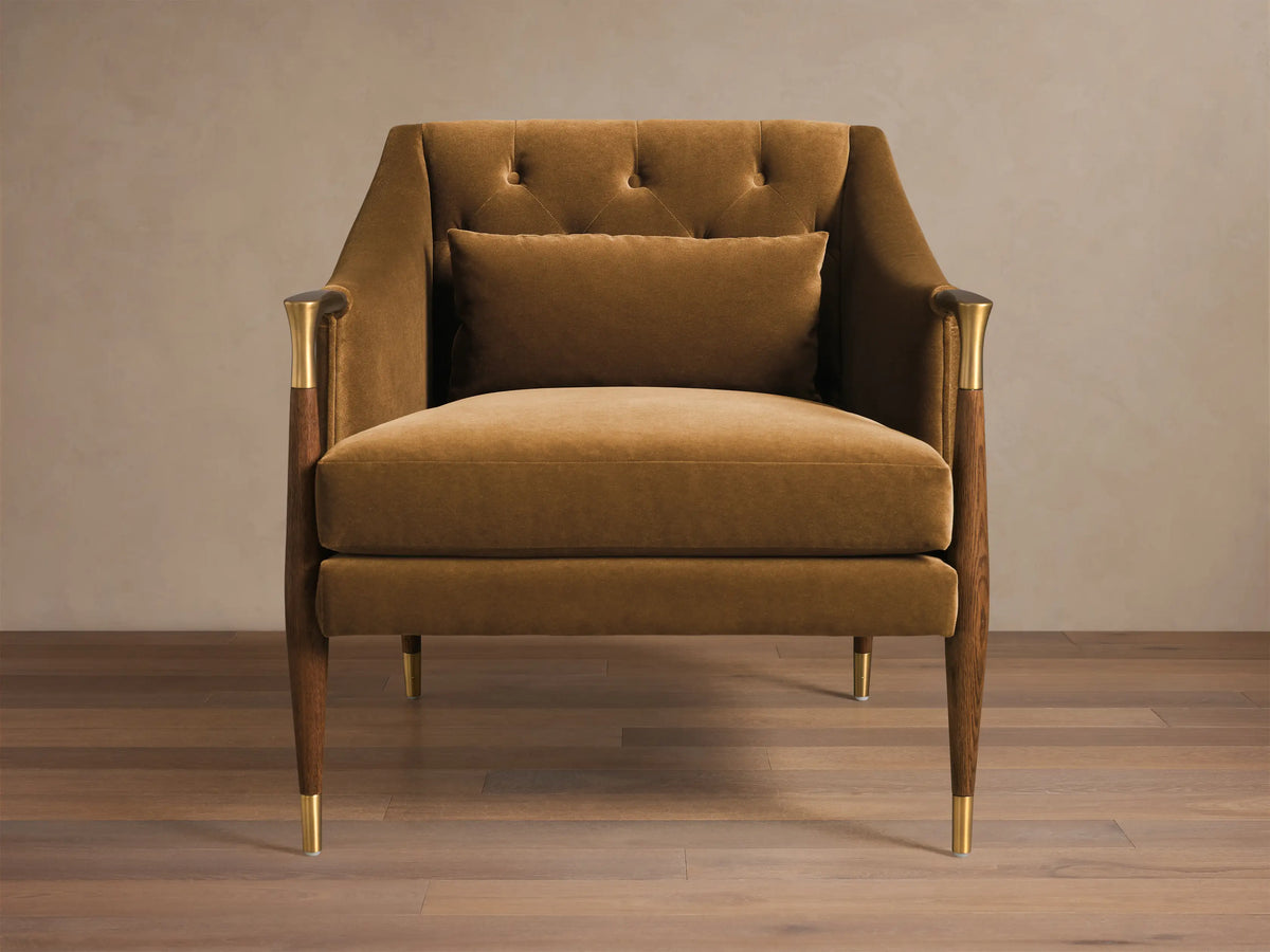 Front view of a golden-brown Fisher Club Chair with velvet upholstery, tufted back, and wooden legs with brass accents.
