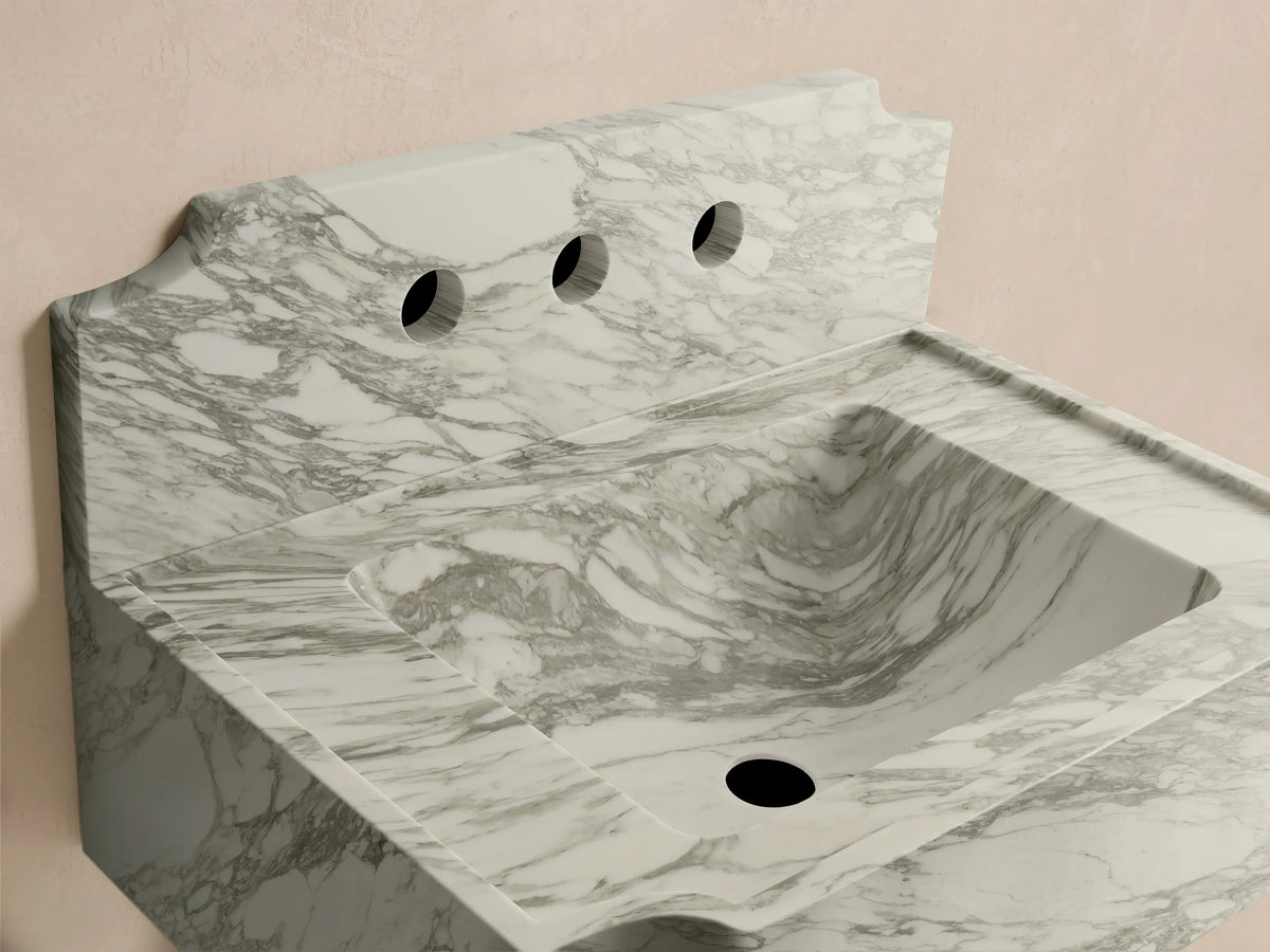 Front 3/4 view of a white marble Dottie Wall-Mounted Sink with Backsplash, featuring grey veining and three faucet holes.