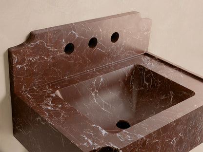 Front view of the reddish-brown Dottie Wall-Mounted Sink with Backsplash, featuring white veining and three faucet holes.