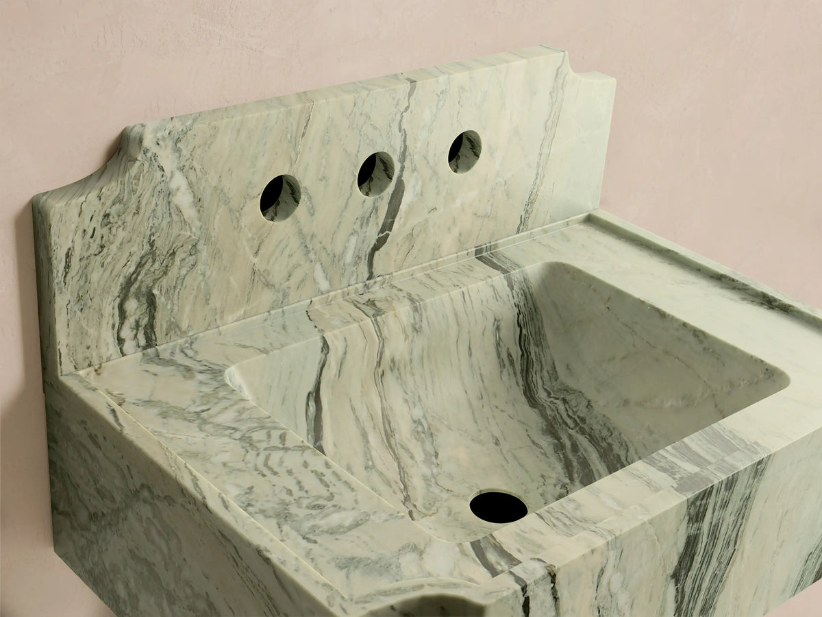Front-right view of the light green and white marbled Dottie Wall-Mounted Sink with Backsplash, with dark grey veining and three faucet holes.
