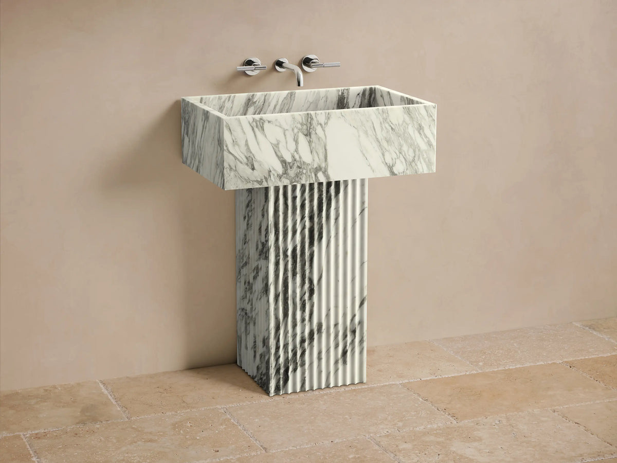 Front view of the white and gray veined Riven Pedestal Sink, featuring a fluted base and rectangular basin.