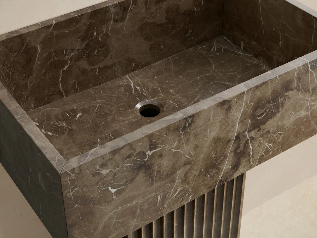 Front view of the dark brown marbled Riven Pedestal Sink, featuring a fluted base and seamlessly integrated top.
