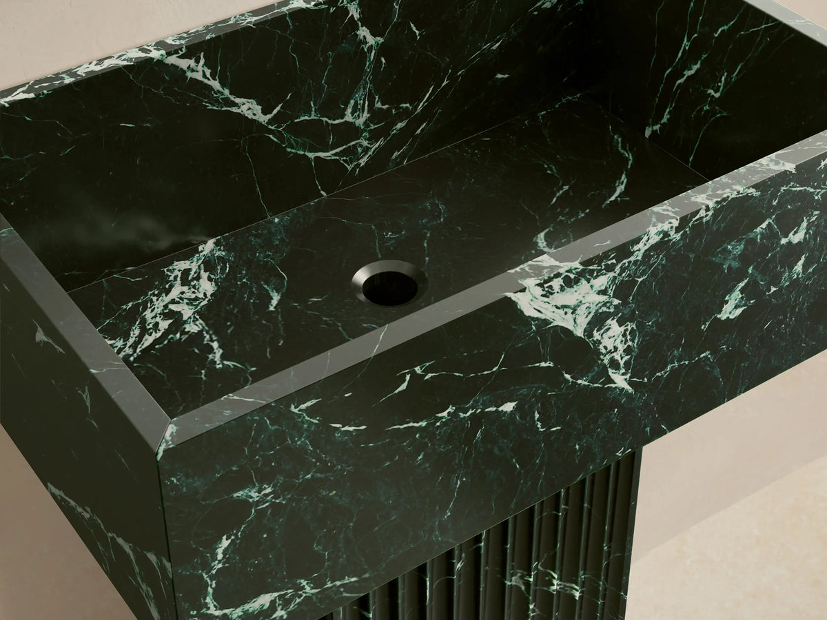 Front view of the dark green Riven Pedestal Sink with white marbling, featuring a rectangular basin and fluted base.