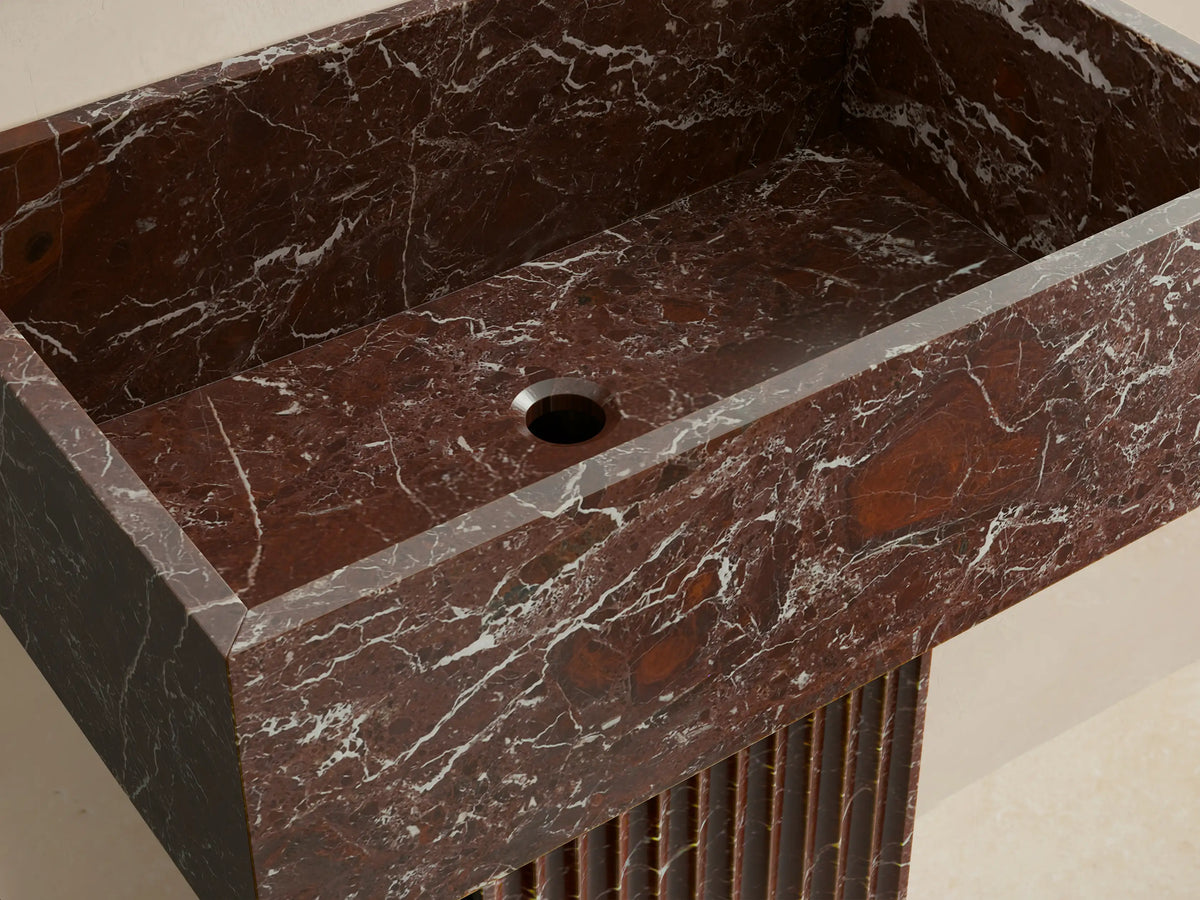 Front view of the dark brown Riven Pedestal Sink with white veining, featuring a rectangular basin and a fluted column base.