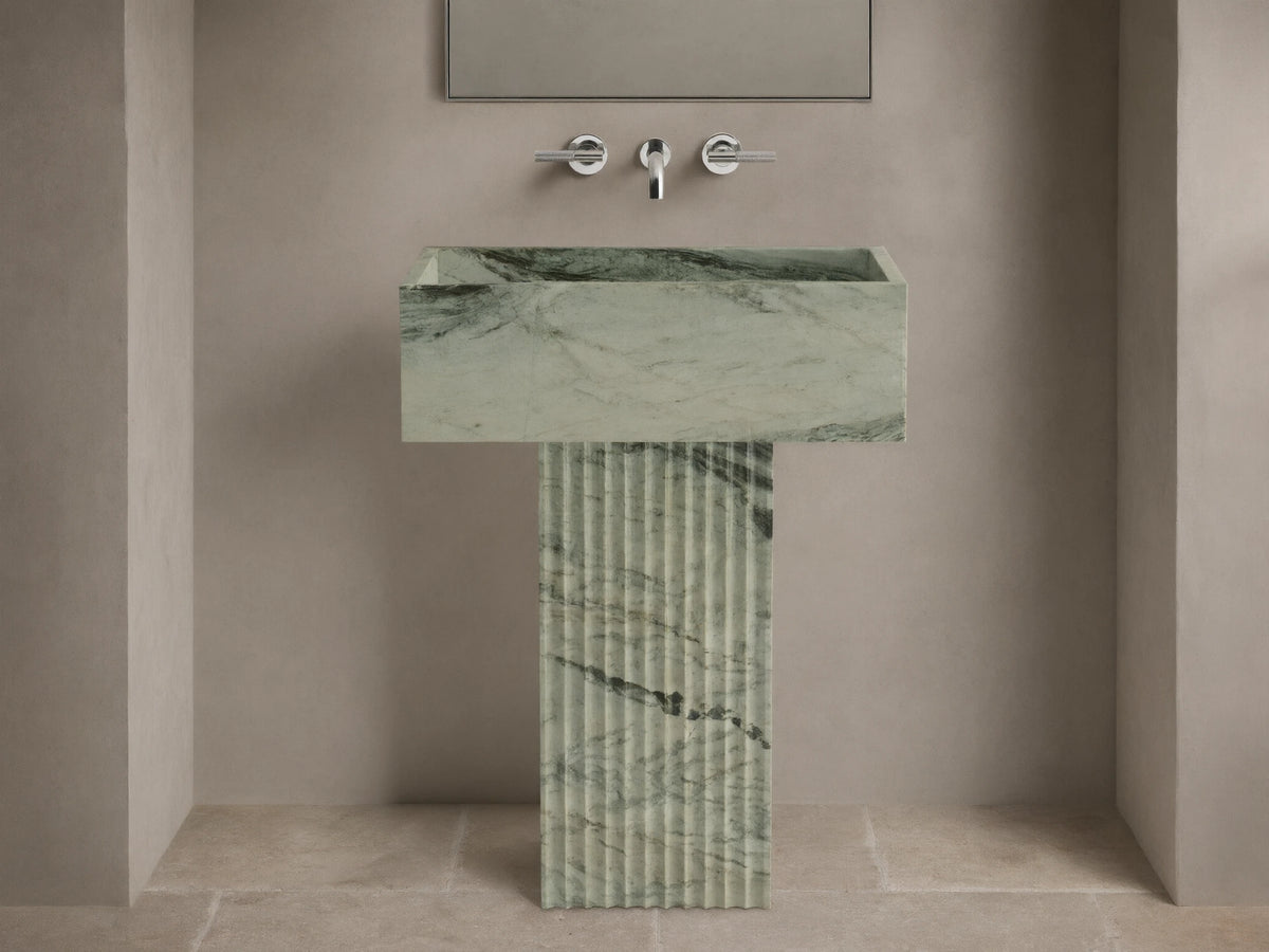 Front view of green marbled Riven Pedestal Sink, showcasing fluted base and natural black veining.