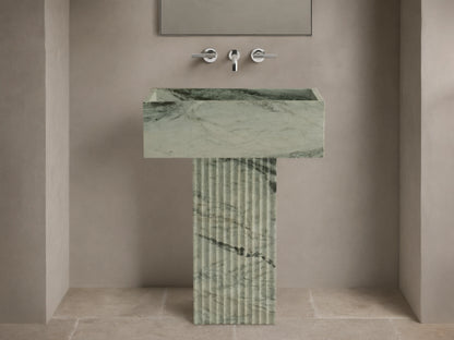 Front view of green marbled Riven Pedestal Sink, showcasing fluted base and natural black veining.