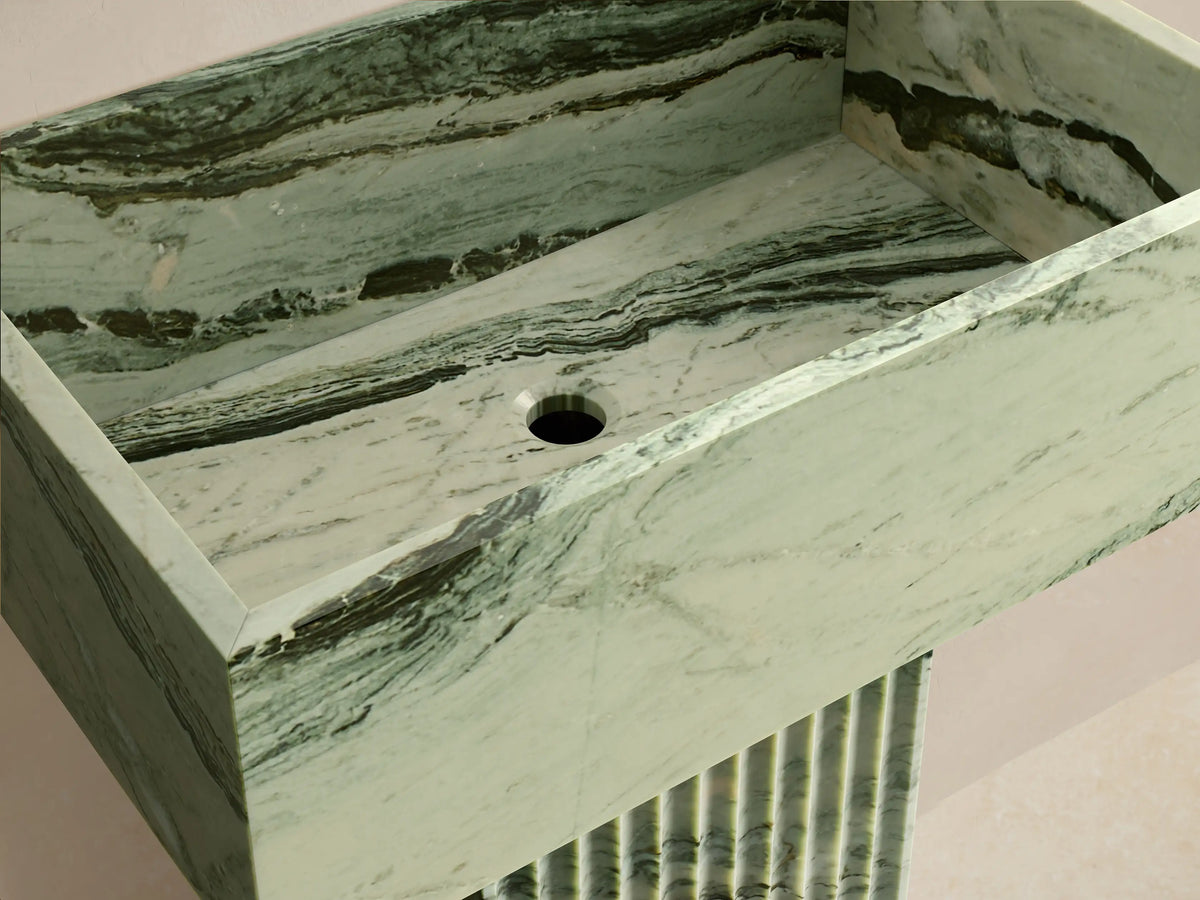 Front view of the green marbled Riven Pedestal Sink with black veins, featuring a rectangular basin and a fluted pedestal base.