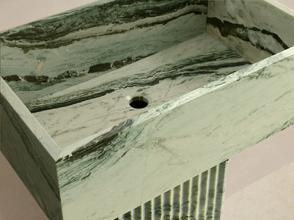 Front view of the green marbled Riven Pedestal Sink with black veins, featuring a rectangular basin and a fluted pedestal base.
