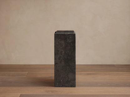 Front view of a dark gray Marmont Pedestal made of honed stone, showing natural veining and a stepped top design.