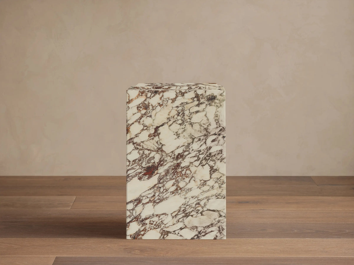 Front view of the Marmont Pedestal, a rectangular pedestal in cream stone with deep red and brown marble veining.