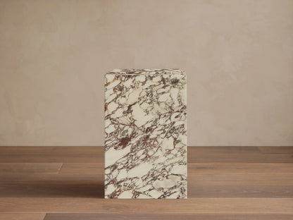 Front view of the Marmont Pedestal, a rectangular pedestal in cream stone with deep red and brown marble veining.