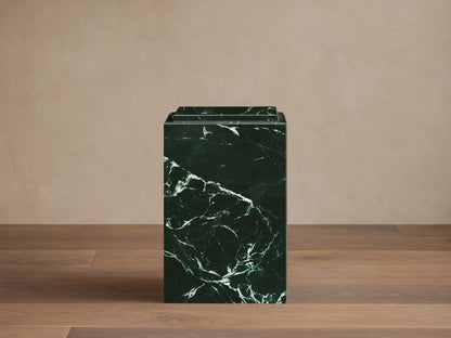 Front view of a dark green marble Marmont Pedestal with white veining and a stepped top.