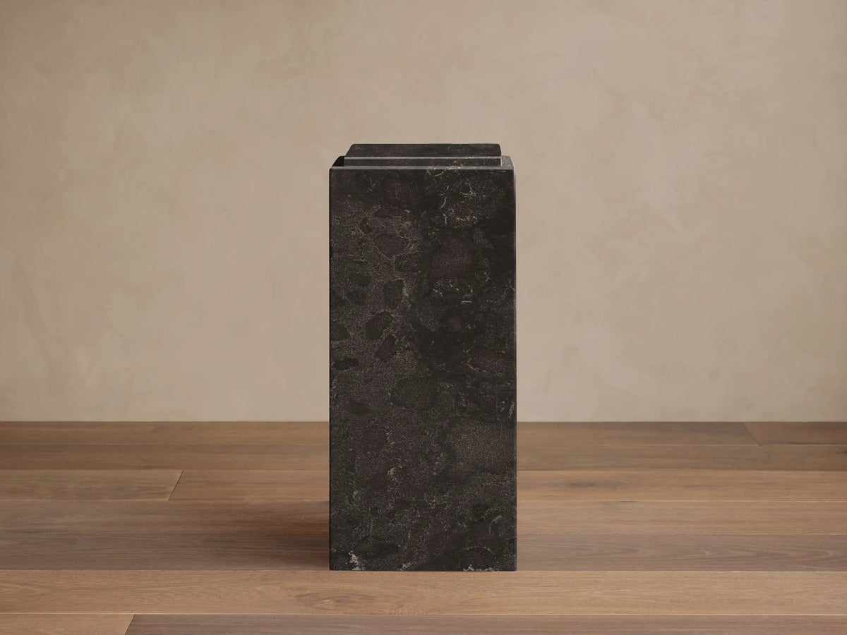 Front view of the Black Marmont Pedestal, a rectangular stone pedestal with subtle light veining and a distinctive stepped top.