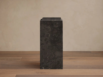 Front view of the Black Marmont Pedestal, a rectangular stone pedestal with subtle light veining and a distinctive stepped top.