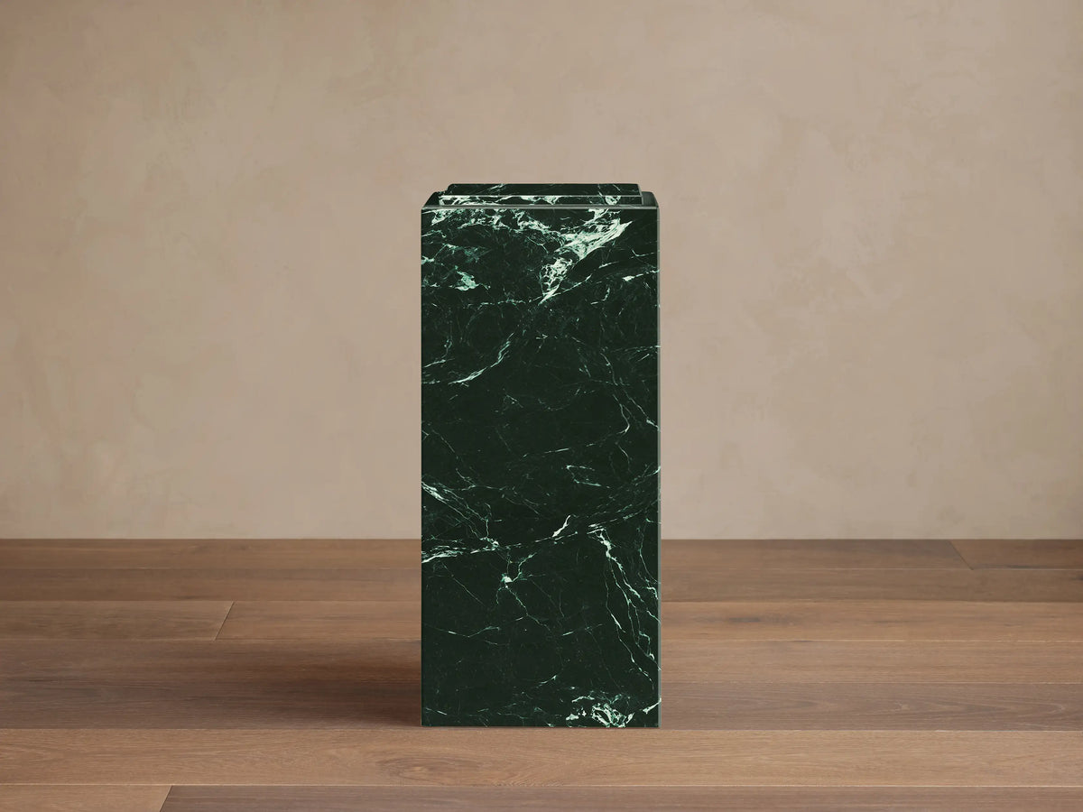 Front view of a dark green Marmont Pedestal made from natural stone with white veining and a matte lacquer finish.