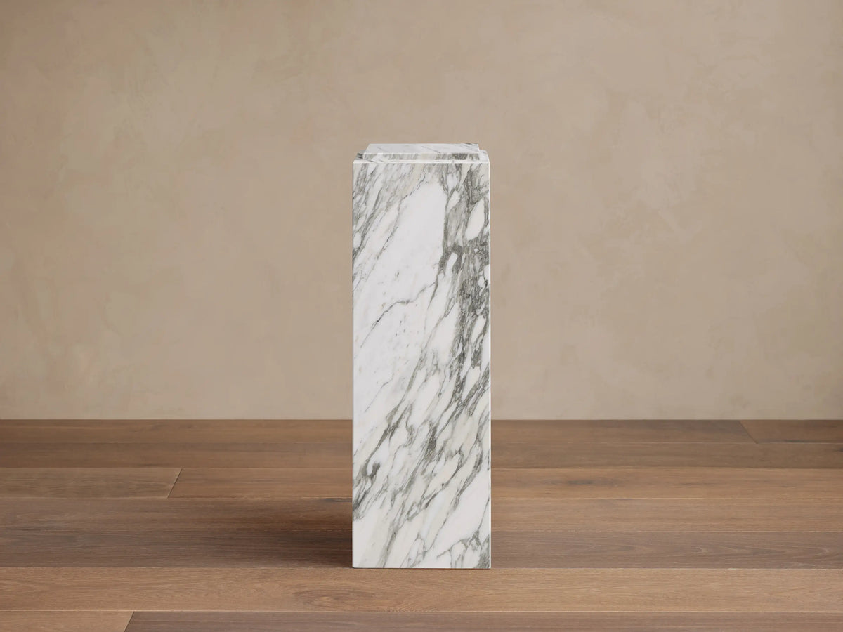Front view of the white Marmont Pedestal, a tall square natural stone column with distinctive gray veining.