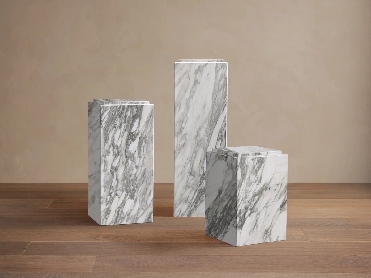 Front view of the white natural stone Marmont Pedestal with grey veining and a matte lacquer finish.