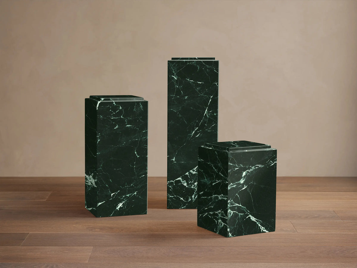 Front view of the dark green Marmont Pedestal with striking white marble-like veining and a tiered top.