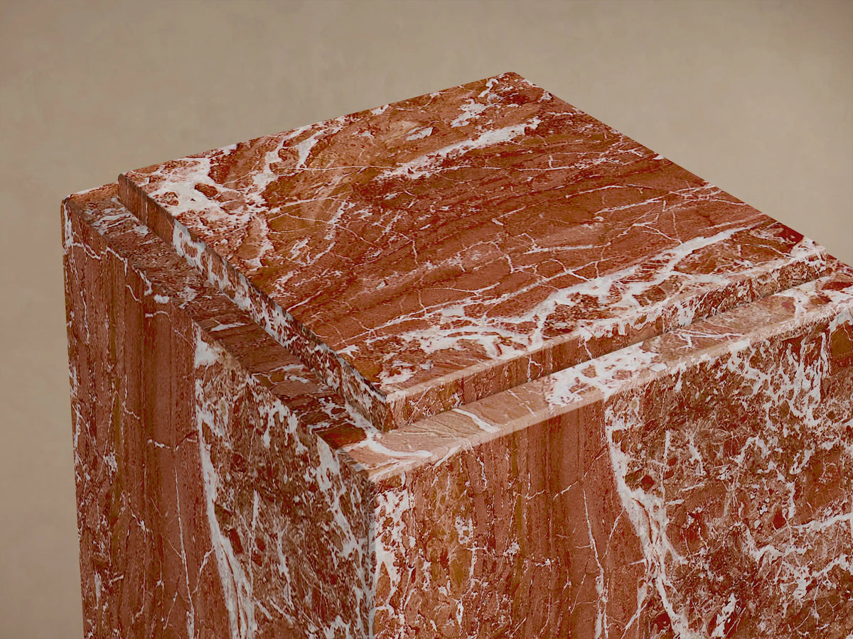 Close-up of the red veined natural stone Marmont Pedestal, showing the stepped top design.