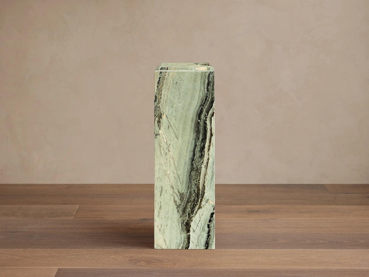 Front view of the green Marmont Pedestal, a tall rectangular column of natural stone with prominent white and black veining.