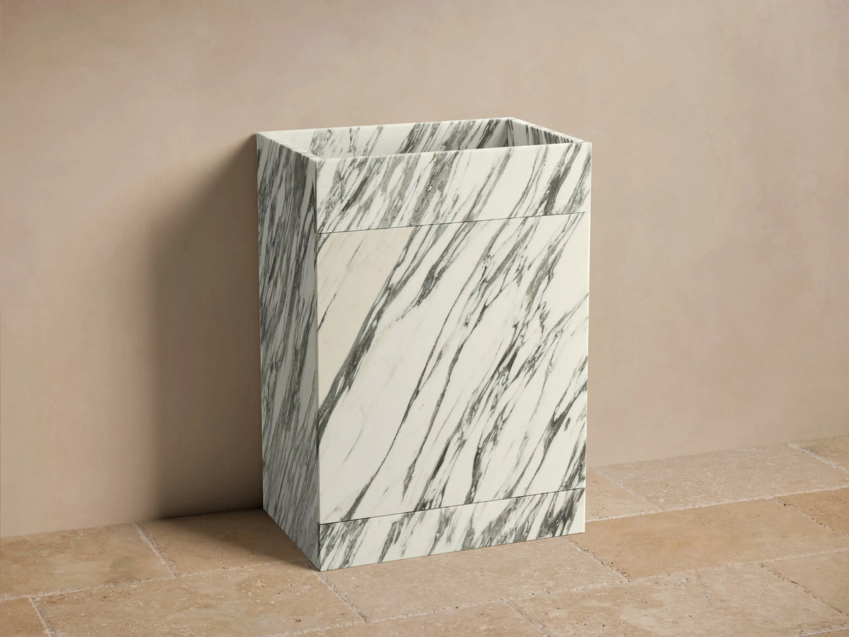 Front view of the Vertiz Pedestal Sink with Storage. White marble with prominent dark gray veining, featuring a sleek rectangular design.