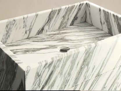 Front view of the white and dark gray marbled natural stone Vertiz Pedestal Sink with Storage.