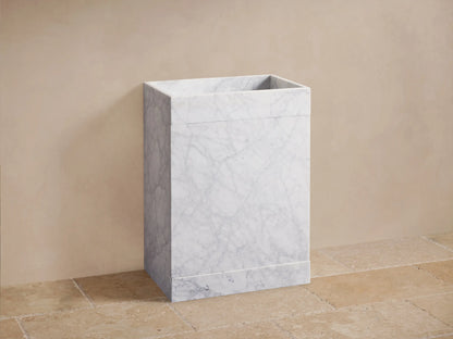 Front view of the White Marble Pedestal Sink, featuring a rectangular basin, prominent gray veining, and chrome faucets.