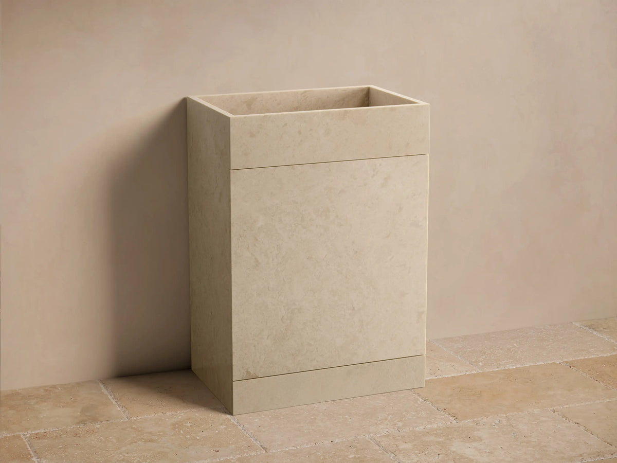 Front view of a beige honed stone Vertiz Pedestal Sink with Storage, featuring a rectangular basin and subtle natural patterns.